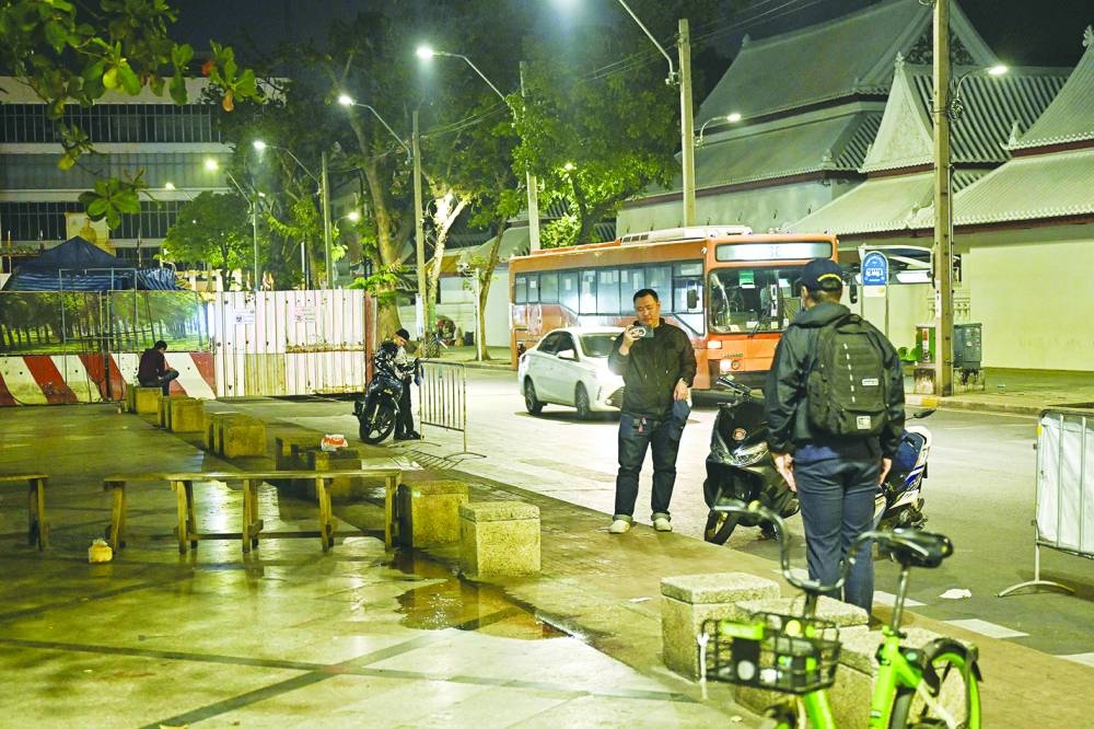 
Central Investigation Bureau members stand near the spot where a Cambodian MP was reportedly shot, in Bangkok yesterday. 