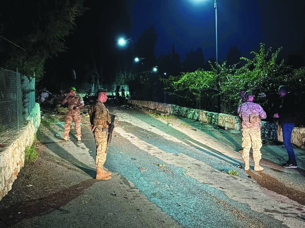 Lebanese army members stand guard at the site of an Israeli strike in Tayr Dibba, in southern Lebanon, yesterday.