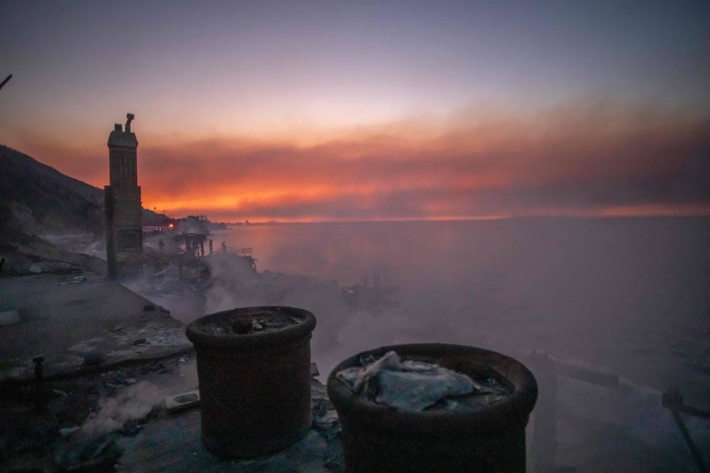 Wildfire smoke and burned houses from the Palisades Fire are seen at dawn on Friday in the Pacific Palisades neighborhood of Los Angeles, California. AFP