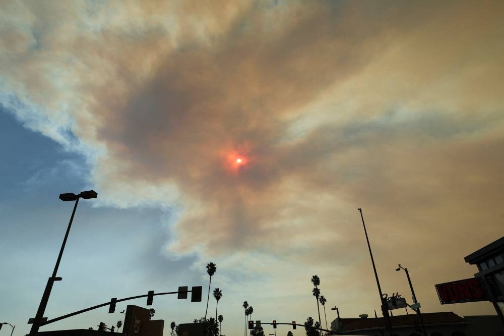 The sun is visible through smoke after the Eaton Fire tore through a neighborhood, on Friday. REUTERS