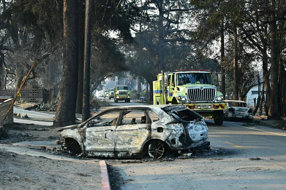 Firefighters travel through destruction left by the Eaton Fire in Altadena, California, on Friday. AFP