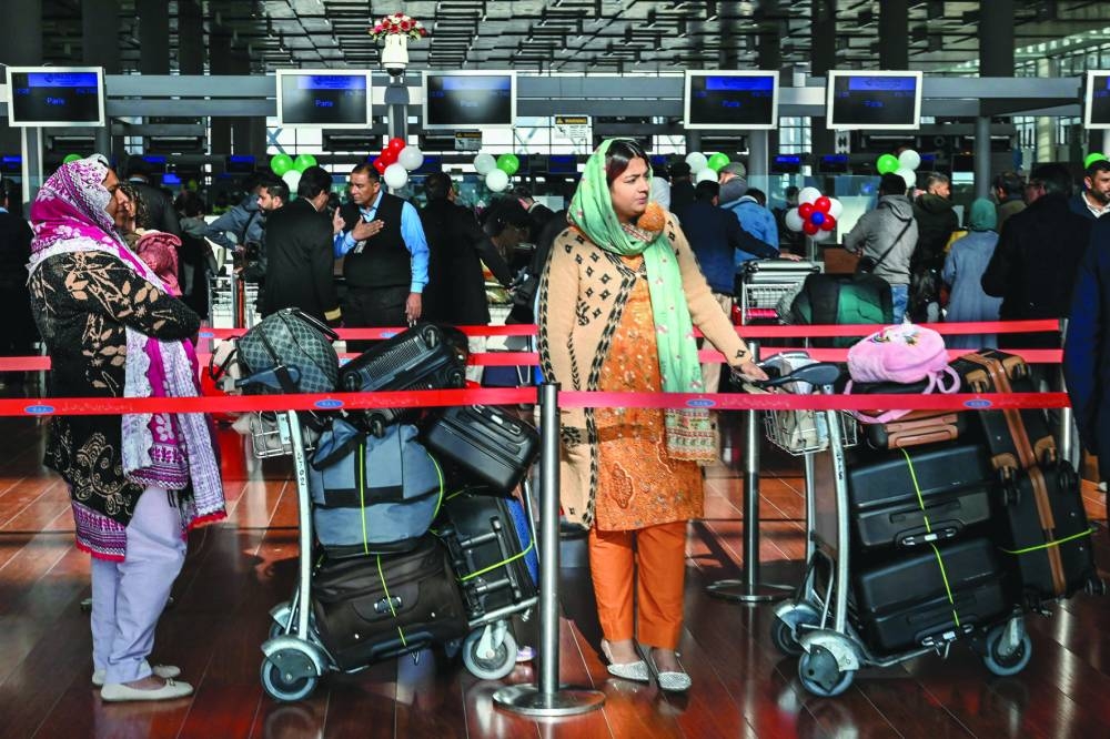 Passengers wait at the immigration counter before boarding their Pakistan International Airlines (PIA) flight to Paris at the Islamabad International Airport. – AFP