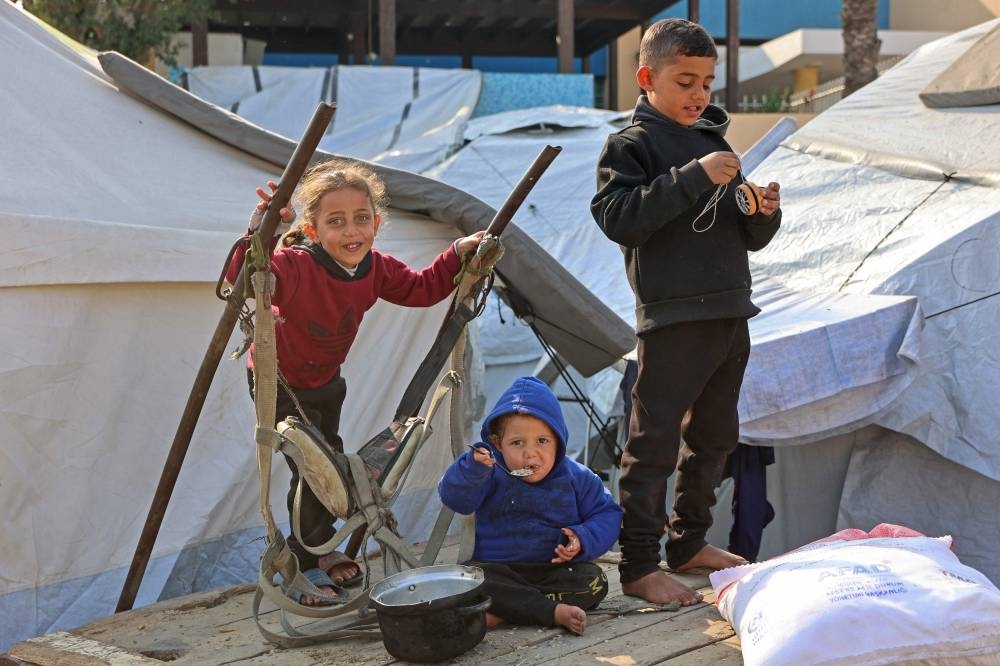 Palestinian children sit outside their makeshift tents in Gaza City on Saturday. AFP