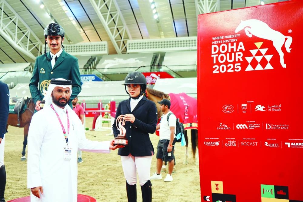 
Mohammed Jaber al-Khayarin, Event Director of Doha International Tour, presents the trophy to Qatar’s promising young rider Haya Khalid al-Hitmi, who finished in third spot in the CSI1* - Faults 
& Time - 115cm class. 