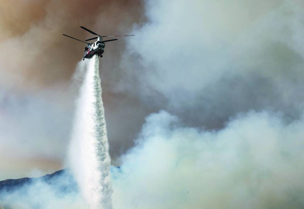 
Right: A firefighting helicopter drops water on the Palisades Fire in Los Angeles. – AFP 