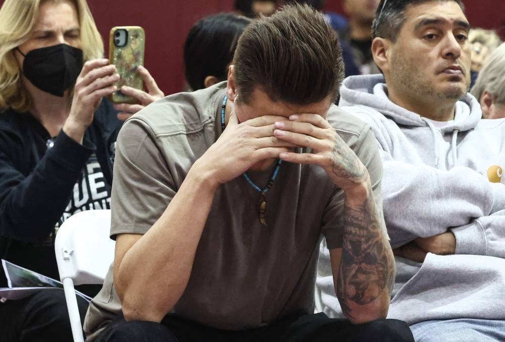 People listen to a speaker at a community meeting for those impacted by the Eaton Fire as wildfires cause damage and loss through LA region on Sunday in Pasadena, California. AFP