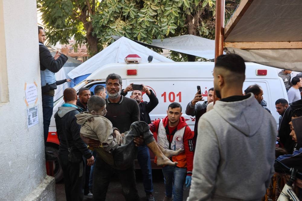 Palestinians transport casualties of Israeli strikes into at Al-Ahli Arab hospital, also known as the Baptist hospital, in Gaza City, on Monday.  AFP