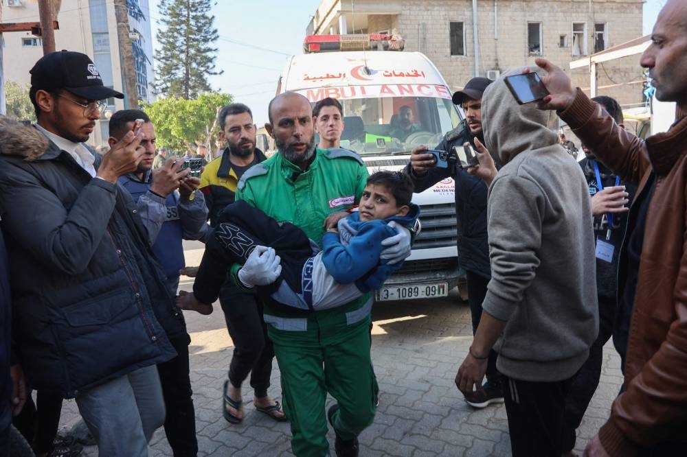 Palestinians transport casualties of Israeli strikes into at Al-Ahli Arab hospital, also known as the Baptist hospital, in Gaza City, on Monday.  AFP