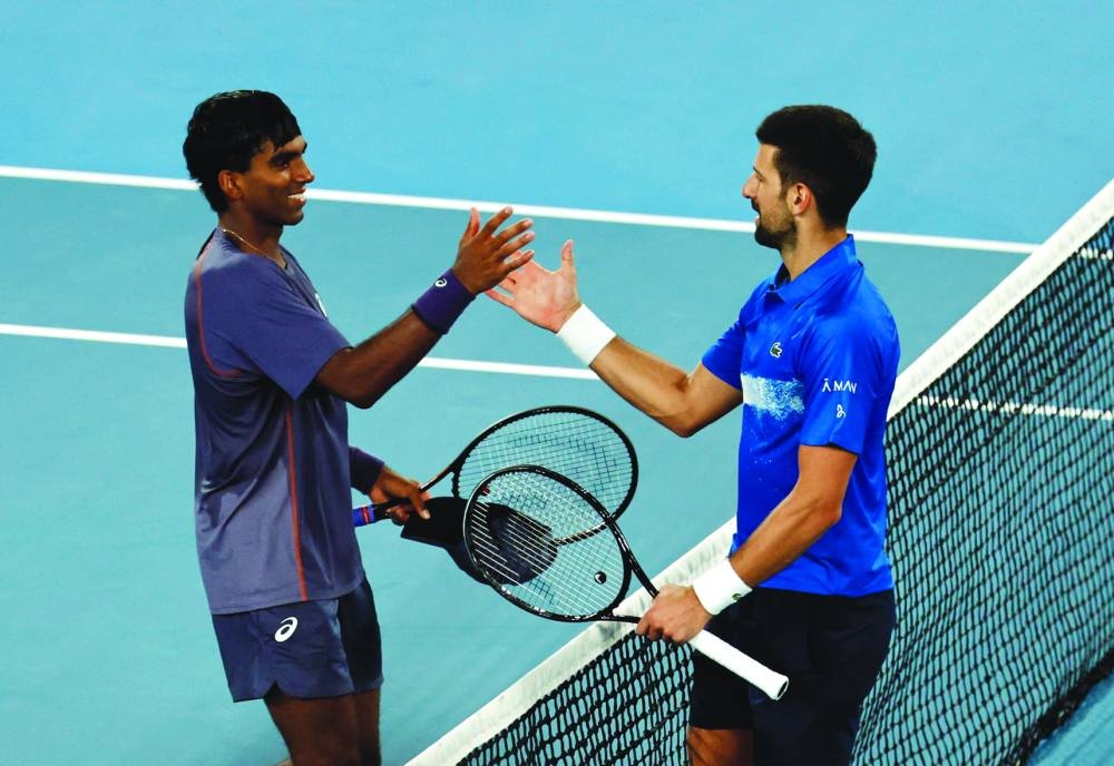 Serbia’s Novak Djokovic greets Nishesh Basavareddy of the United States after winning his first round match at the Australian Open in Melbourne on Monday. (Reuters)