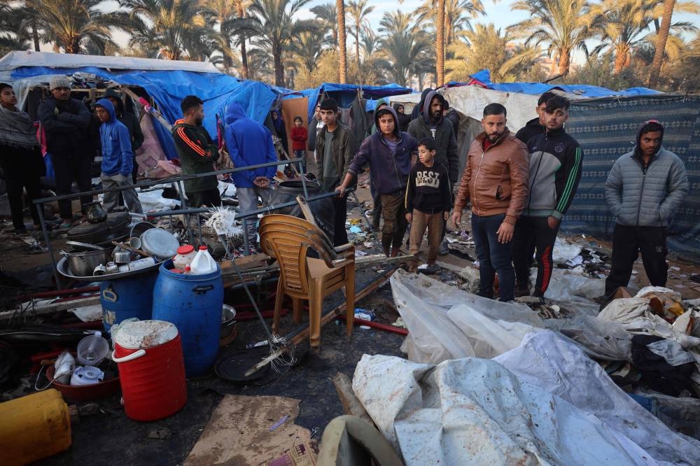 Palestinians inspect a destroyed tent shelter following Israeli airstrikes at a makeshift displacement camp in Deir el-Balah in the central Gaza Strip, on Tuesday. AFP