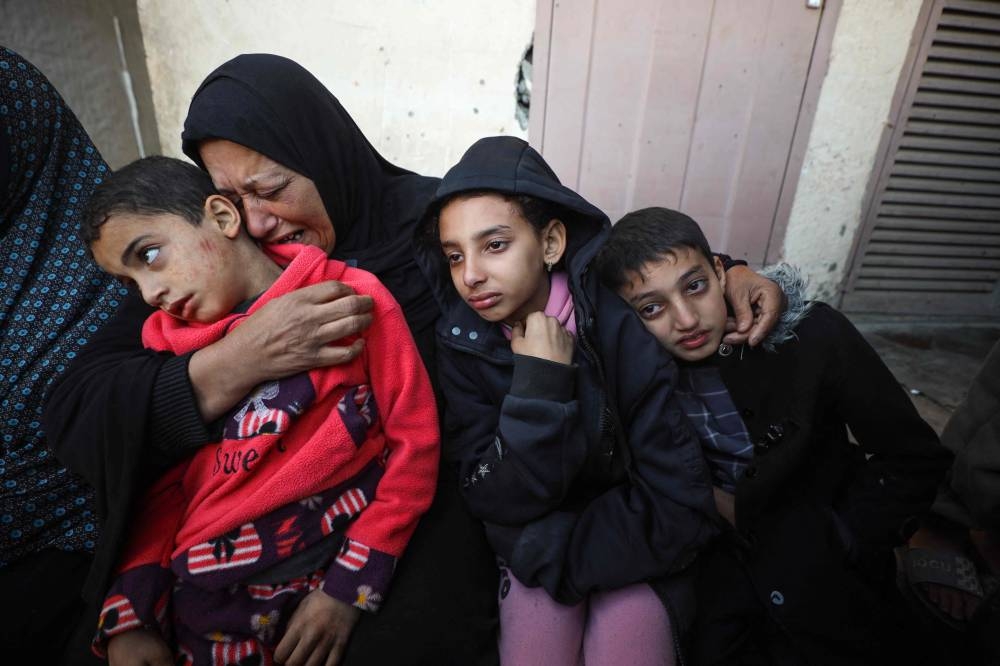 Palestinians mourn the death of their relatives, including children, who were killed in an Israeli airstrike on their shelter in Deir el-Balah in the central Gaza Strip, on Tuesday. AFP