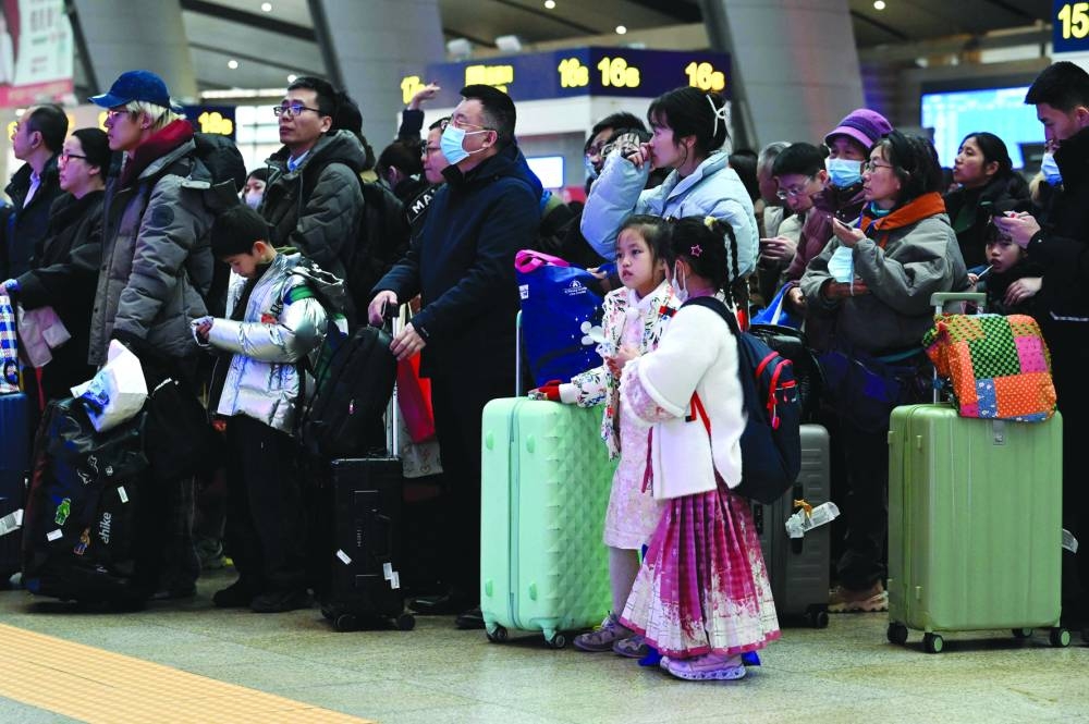 
Passengers wait to check in at a railway station in Beijing yesterday. 