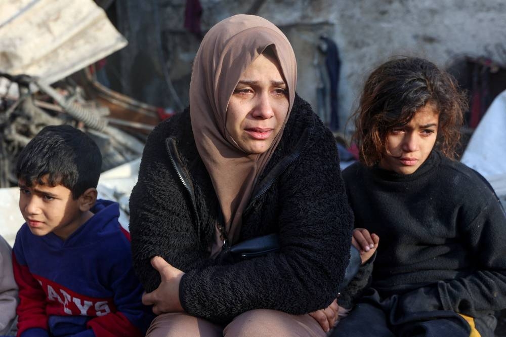 A woman cries as she watches the destruction in the aftermath of an Israeli strike at the Al-Farabi school in the centre of Gaza City, which is sheltering a number of displaced people, on Wednesday. AFP
