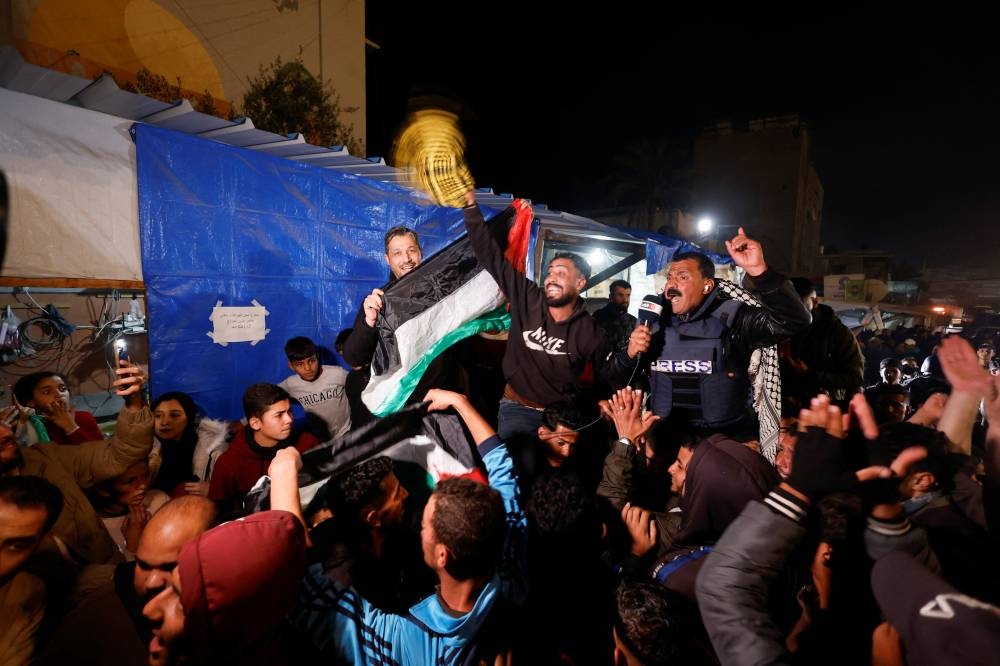 Palestinians react to news on a ceasefire deal with Israel, in Khan Younis in the southern Gaza Strip, Wednesday. REUTERS