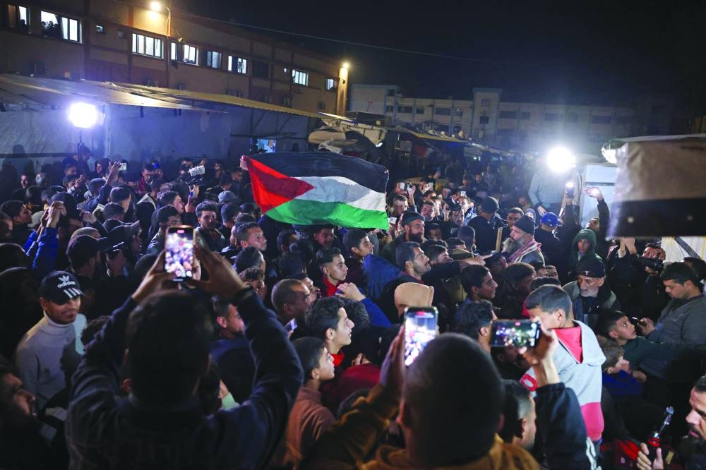 People watch a television along a street in Khan Younis in the southern Gaza Strip Wednesday