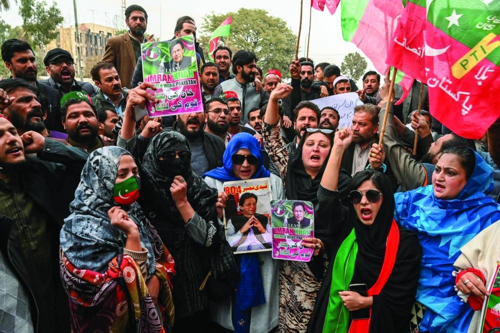 Pakistan's imprisoned former prime minister Imran Khan's supporters hold Khan's portraits during a protest in Peshawar on January 17, 2025. A Pakistan court on January 17 convicted former Pakistan prime minister Imran Khan and his wife Bushra Bibi in a landmark graft case, sentencing Khan to 14 years in prison. (Photo by Abdul MAJEED / AFP)