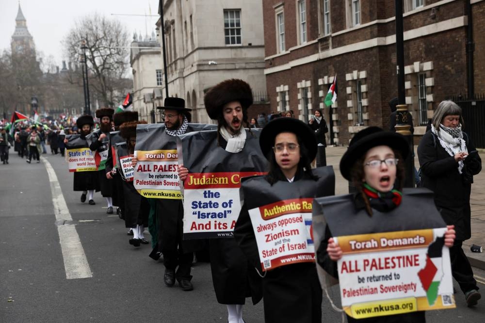 Ultra-Orthodox Jews hold placards at a demonstration in support of Palestinians in Gaza, after Israel and Hamas reached a ceasefire deal, in London, on Saturday. REUTERS