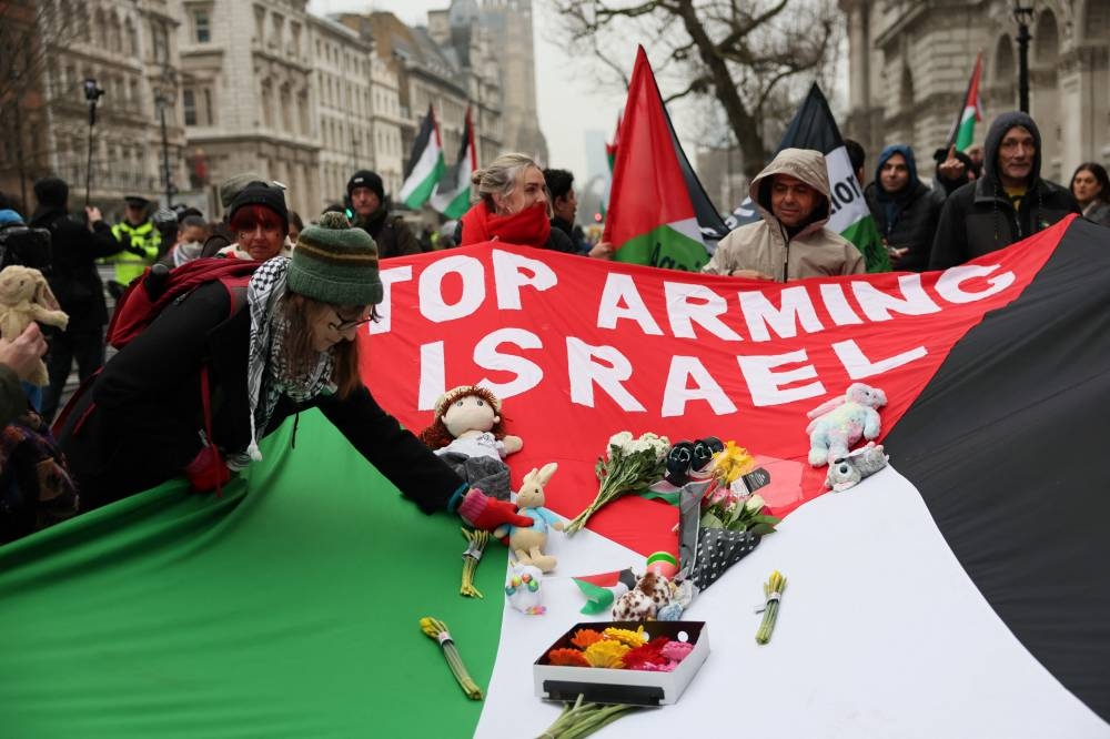 Protesters hold a flag during a demonstration in support of Palestinians in Gaza, after Israel and Hamas reached a ceasefire deal, in London, on Saturday. REUTERS