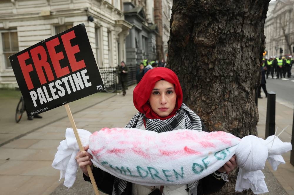 A protester holds a placard during a demonstration in support of Palestinians in Gaza, after Israel and Hamas reached a ceasefire deal, in London, on Saturday. REUTERS