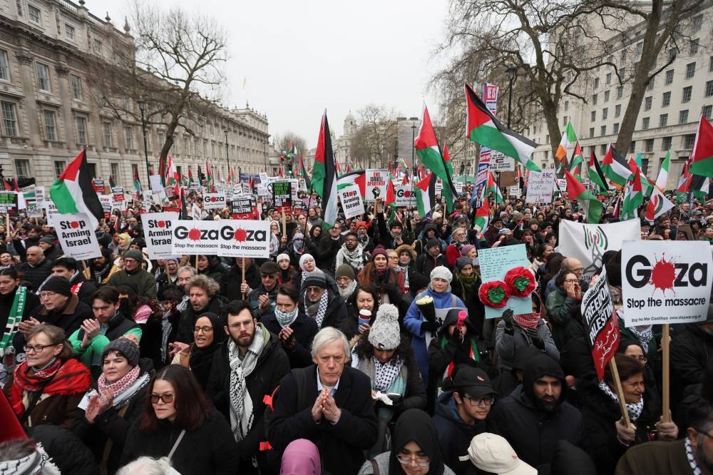 Protesters hold placards during a demonstration in support of Palestinians in Gaza, after Israel and Hamas reached a ceasefire deal, in London, on Saturday. REUTERS