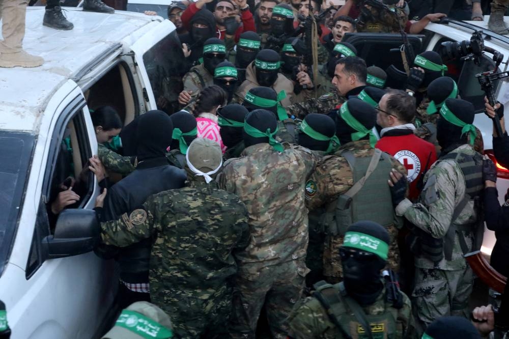 Hamas hands over hostages kidnapped during the October 7, 2023, attack on Israel by Hamas, to members of the International Committee of the Red Cross (ICRC) as part of a ceasefire and a hostages-prisoners swap deal between Hamas and Israel, in Gaza City, on Sunday. REUTERS