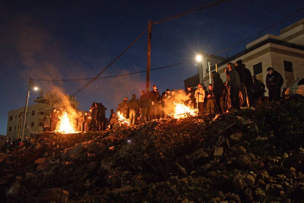 Family members and relatives of Palestinian prisoners, stand around bonfires while waiting for their release, on a hill above the Ofer Prison, in the west of Ramallah on, on Sunday. AFP