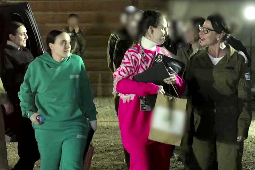 The three Israeli hostages who had been abducted during the October 7, 2023 attacks by Palestinian militants, after disembarking from the International Committee of the Red Cross (ICRC) vehicle upon behind handed over to Israeli forces at an undisclosed location on Sunday. AFP PHOTO / Handout / Israeli Army