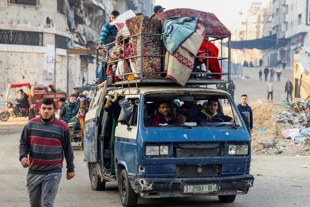 Displaced Palestinians with their belongings in a vehicle makes their way past rubble as they attempt to return to their homes following a delay in the ceasefire between Israel and Hamas over the hostage list, in the northern Gaza Strip on Sunday. REUTERS