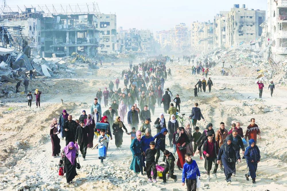 Scores of displaced Palestinians walk along a road in the Saftawi area of Jabalia, as they leave areas near Gaza City where they had taken refuge, toward the further northern part of the Gaza Strip, shortly after a ceasefire deal in the war. 