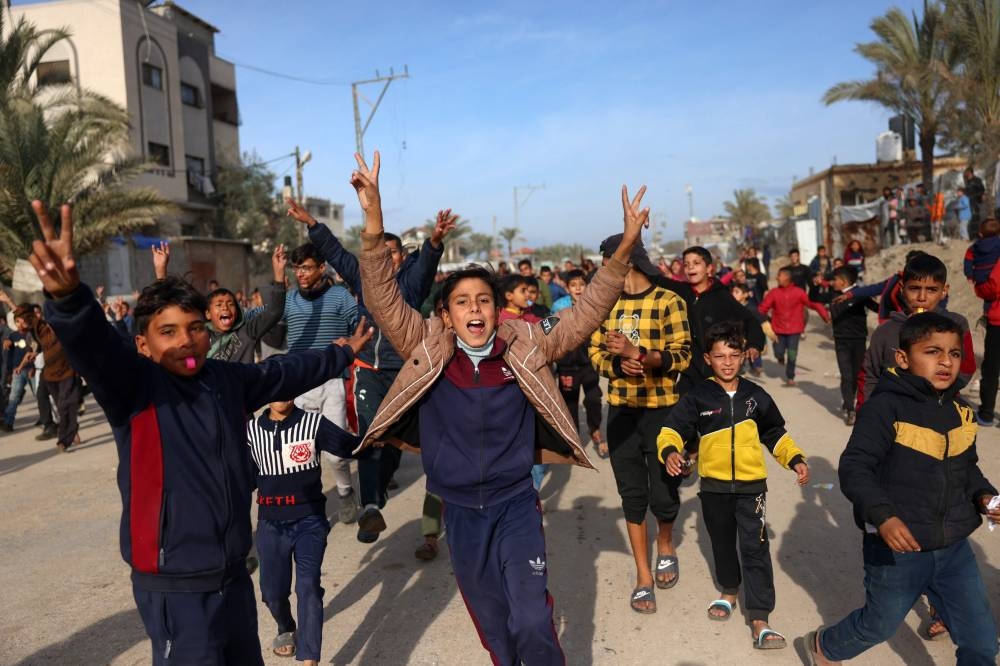 Children cheer in Nuseirat in the central Gaza Strip, Sunday.