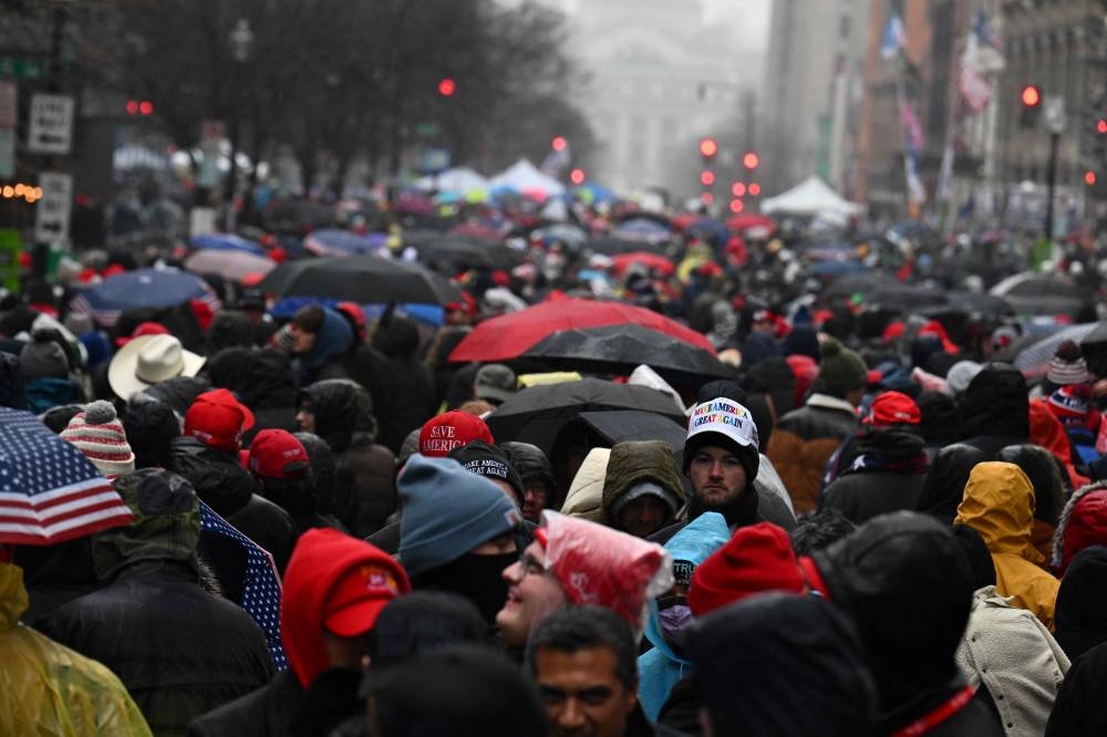 Supporters of US President-elect Donald Trump wait outside for a victory rally at Capital One Arena in Washington, DC Sunday