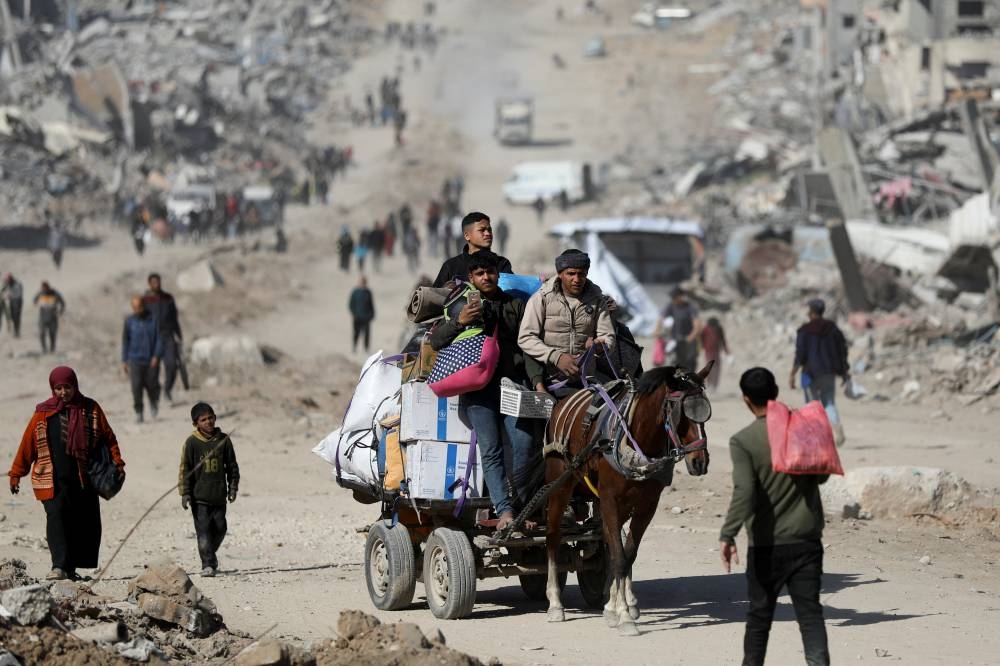Palestinians make their way past the rubble of destroyed houses and buildings, following a ceasefire between Israel and Hamas, in Jabalia in the northern Gaza Strip, on Tuesday. REUTERS