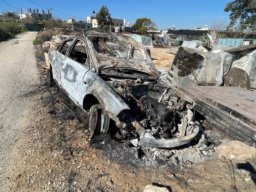 A burned-out car lies on the side of a road after an Israeli settlers attack near Qalqilya in the Israeli-occupied West Bank, on Tuesday. REUTERS
