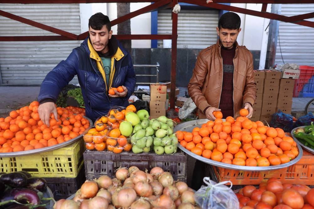 Men sell vegetables at a street market in Al-Daraj neighbourhood in Gaza City, on Tuesday, on the third day of a ceasefire deal in the war between Israel and Hamas in the Palestinian territory. AFP