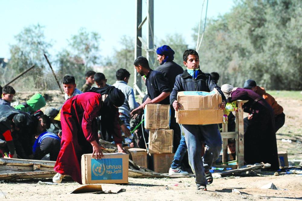 A boy walks with a humanitarian aid package in al-Shoka, east of Rafah in the southern Gaza Strip on Tuesday.