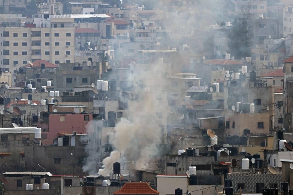 Smoke rises from an area during a large-scale Israeli army raid in Jenin, in the occupied West Bank on Friday. A Palestinian official said hundreds of people began leaving their homes in a flashpoint area of the occupied West Bank on Thursday, as Israeli forces pressed a deadly operation there. AFP
