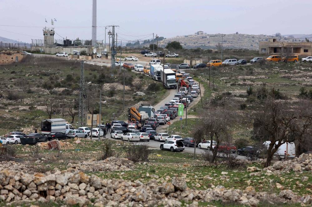Commuters wait in their vehicles at the Israeli Atara checkpoint on route 465 near Ramallah in the occupied West Bank on Wednesday. All over the West Bank, commuters have been finding that their journey to work takes much longer since the Gaza ceasefire started. AFP