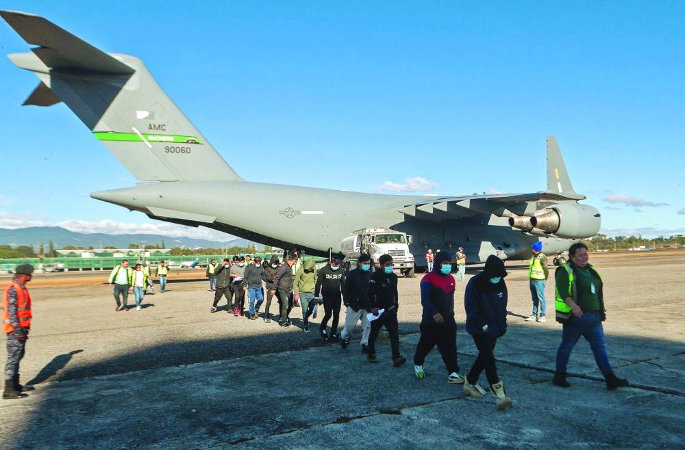 Handout picture released by Guatemalan Migration Institute shows Guatemalan migrants descending from an US military plane at the Guatemalan Air Force Base in Guatemala City, after being deported from US. – AFP
