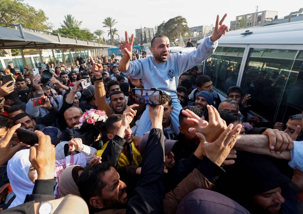 A freed Palestinian prisoner gestures as he is greeted by people after being released by Israel as part of a hostages-prisoners swap and a ceasefire deal in Gaza between Hamas and Israel, in Khan Younis in the southern Gaza Strip,on Saturday. REUTERS