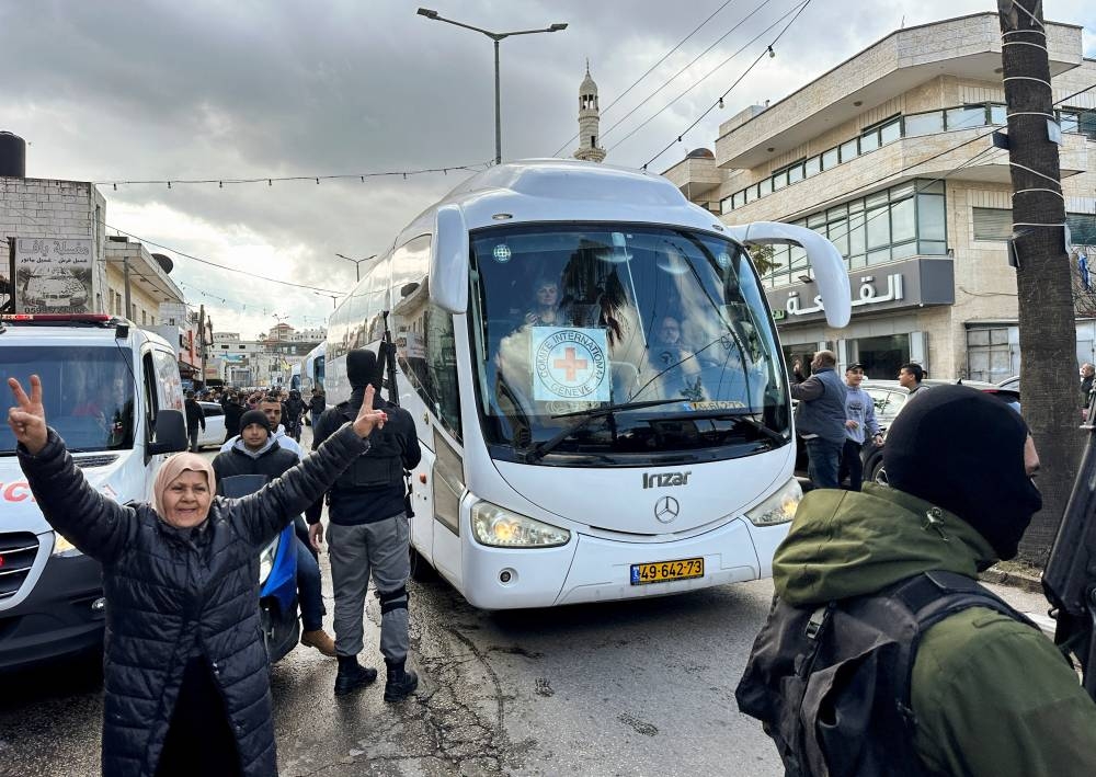 A woman gestures next to a bus carrying freed Palestinian prisoners after they were released from an Israeli jail in the Israeli-occupied West Bank, Saturday. REUTERS