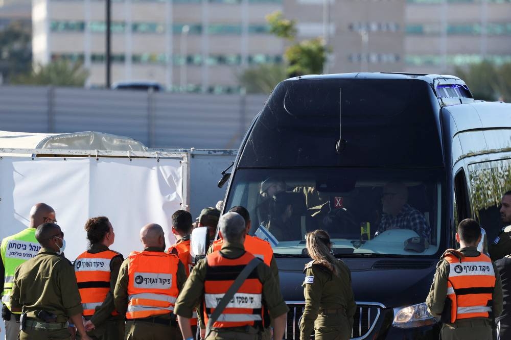 People gather as released Israeli hostages board a vehicle at Beilinson Schneider complex, in Petah Tikva, Israel, on Saturday. REUTERS