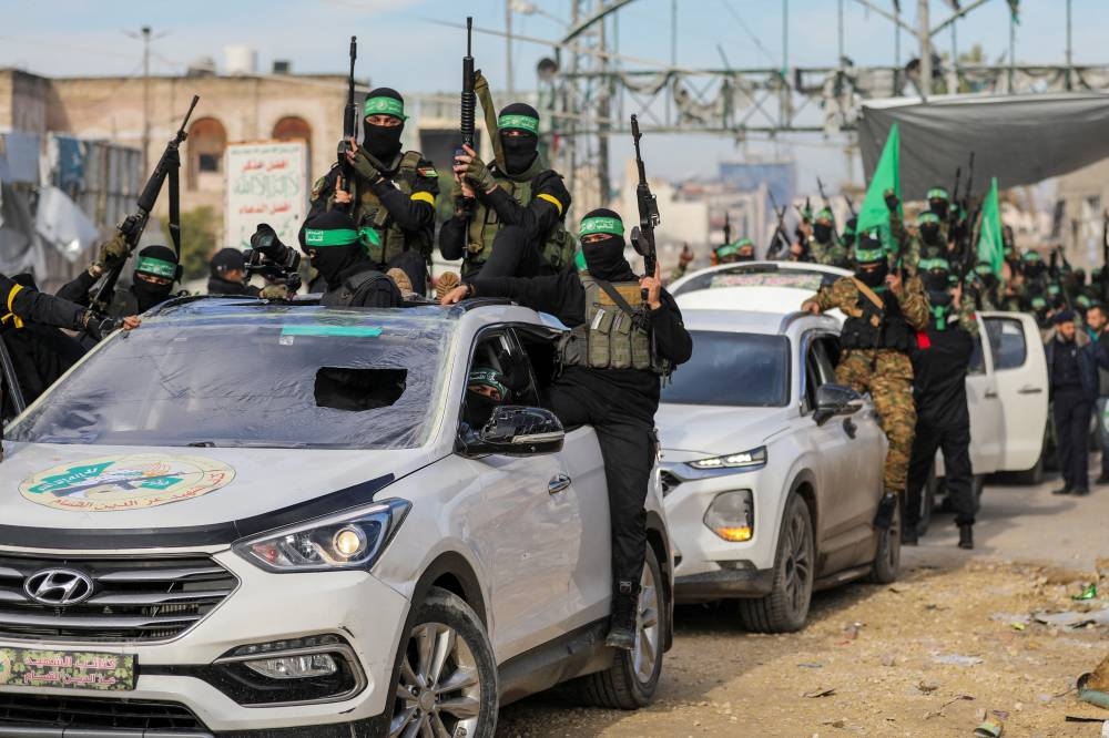 Hamas parade before they hand over the hostages to members of the International Committee of the Red Cross (ICRC) in Gaza City, on Saturday. REUTERS