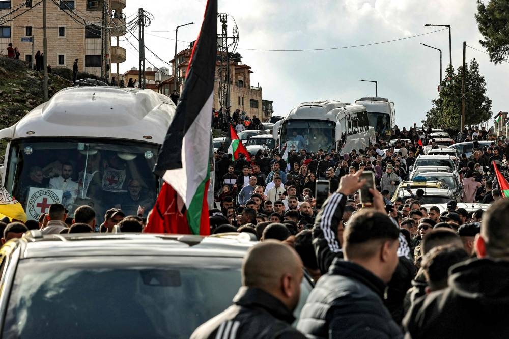 People cheer as buses of the International Committee of the Red Cross (ICRC) carrying Palestinian prisoners released by Israel arrive in Ramallah in the occupied West Bank on Saturday. AFP