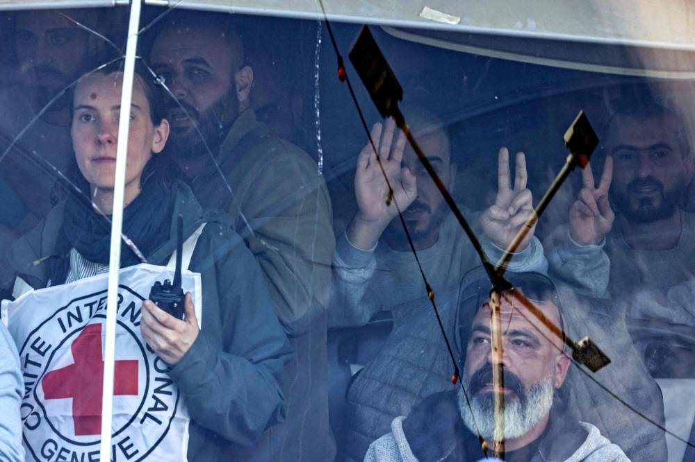 Former Palestinian prisoners released by Israel gesture as they ride in one of the buses of the International Committee of the Red Cross (ICRC0 as it moves in the town of Beitunia near Ramallah in the occupied West Bank on Saturday. AFP