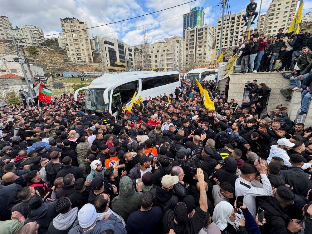 People gather near a bus carrying freed Palestinian prisoners after they were released from an Israeli jail, in Ramallah, in the Israeli-occupied West Bank, on Saturday. REUTERS
