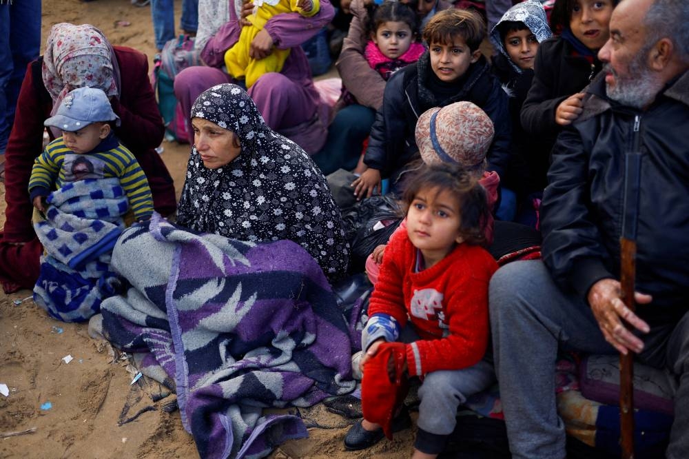 Palestinians wait to be allowed to return to their homes in northern Gaza after they were displaced to the south at Israel's order during the war, in the central Gaza Strip, on Sunday. REUTERS