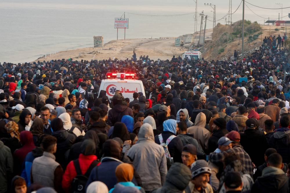 Palestinians wait to be allowed to return to their homes in northern Gaza after they were displaced to the south at Israel's order during the war, in the central Gaza Strip, on Sunday. REUTERS