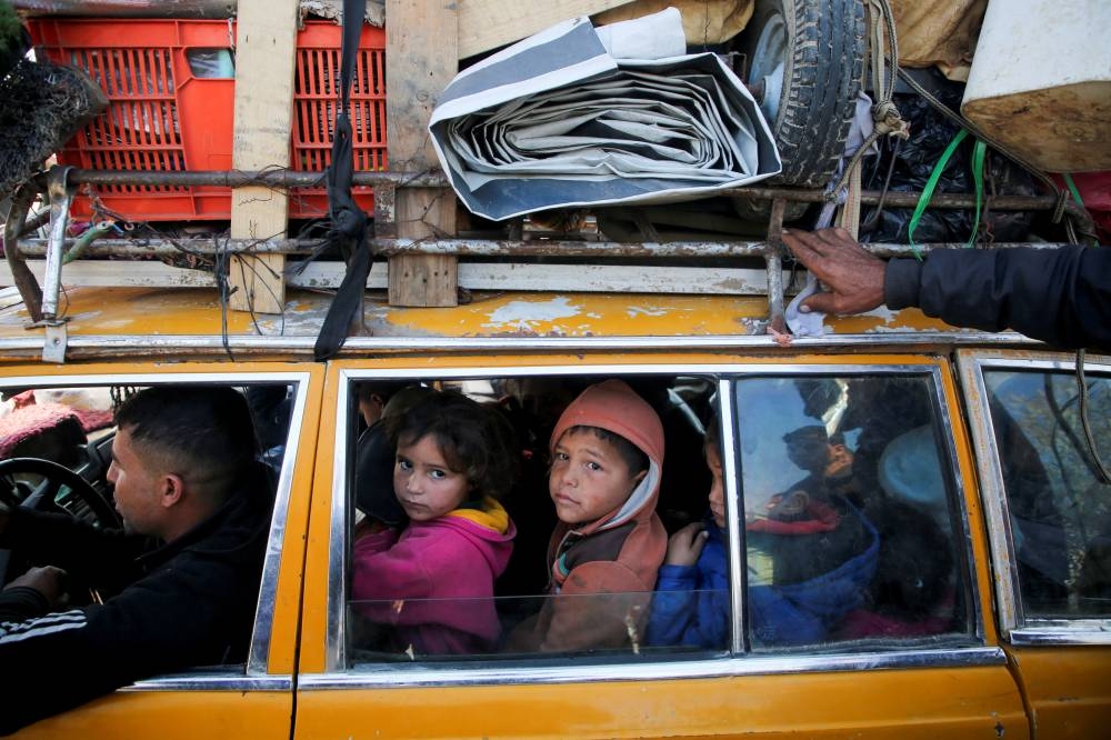 Palestinians, who were displaced to the south at Israel's order during the war, wait to head back to their homes in northern Gaza by vehicle through Salahudeen Road, in the central Gaza Strip, on Monday. REUTERS