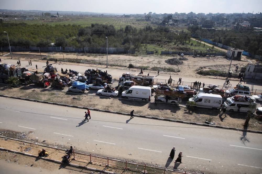 Palestinians, who were displaced to the south at Israel's order during the war, wait to head back to their homes in northern Gaza by vehicle through Salahudeen Road, in the central Gaza Strip, on Monday. REUTERS