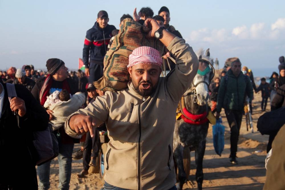 Palestinians, who were displaced to the south at Israel's order during the war, make their way back to their homes in northern Gaza, in Gaza City, on Monday. REUTERS